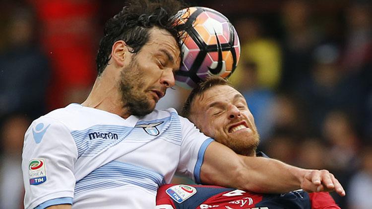 Marco Parolo (kiri) duel dengan Luca Rigoni. Copyright: MARCO BERTORELLO/AFP/Getty Images