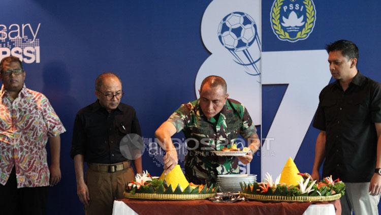 Ketua Umum PSSI memotong tumpeng dalam perayaan HUT PSSI.