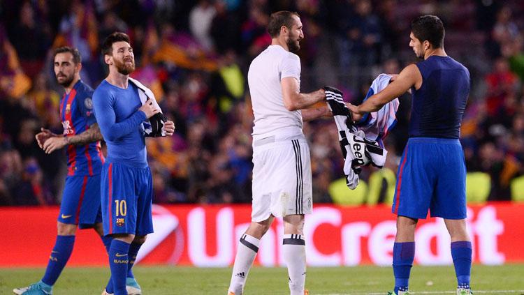 Bek tengah Juventus, Giorgio Chiellini (tengah) dan Luis Suarez saling bertukar jersey disaksikan oleh Lionel Messi (paling kiri).