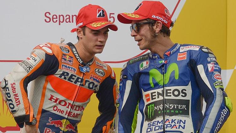 Dani Pedrosa (kiri) tampak mendengarkan perbincangan Valentino Rossi. Copyright: MOHD RASFAN/AFP/Getty Images