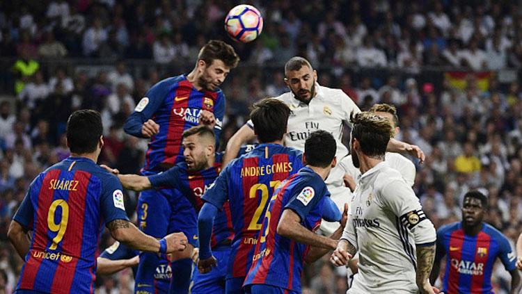 Bek Barcelona Gerard Pique (atas kiri) mengepalai bola dengan pemain Real Madrid Karim Benzema