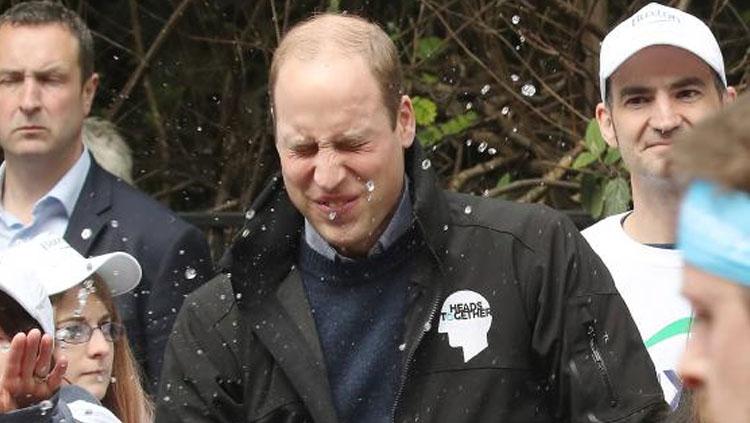 Pangeran William terkena semburan air saat menonton London Marathon 2017. - INDOSPORT