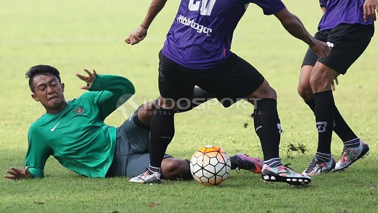 Febri Haryadi terjatuh karena tidak bisa melewati kedua pemain Persita Tangerang.