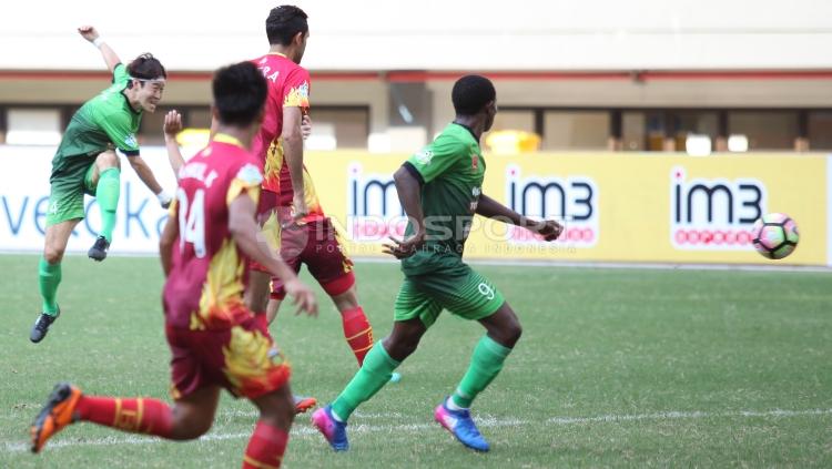 Hong Soon-hak (PS TNI) melepaskan tendangan.