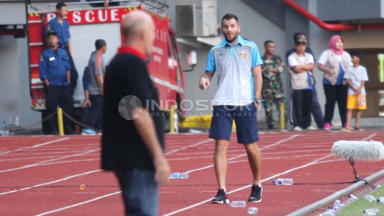Pelatih Bhayangkara FC, Simon McMrenemy terlihat berdebat dengan pelatih PS TNI, Laurent Hatton.