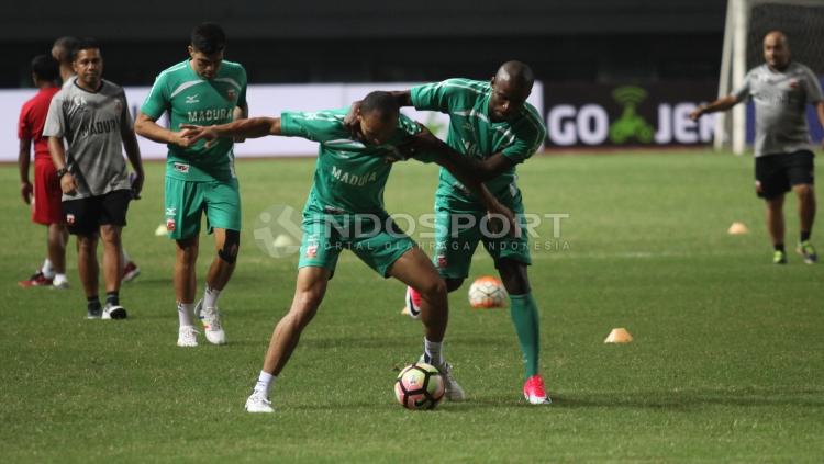 Peter Osase Odemwingi berebut bola dengan Greg Nwokolo pada latihan