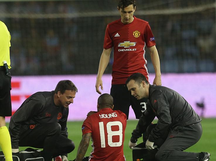 Young mendapatkan perawatan saat mengalami cedera di laga melawan Celta Vigo. Copyright: John Peters/Man Utd via Getty Images