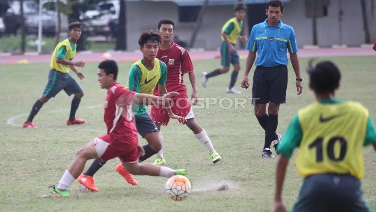 Pemain Timnas U-16 tampak berhasil melewati pemain PPLP DKI yang akan merebut bola darinya.