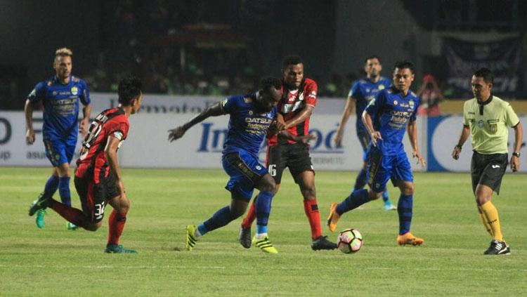 Michael Essien saat beraksi melewati hadangan para pemain Persipura Jayapura di pekan kelima Liga 1. Copyright: Muhammad Ginanjar/INDOSPORT