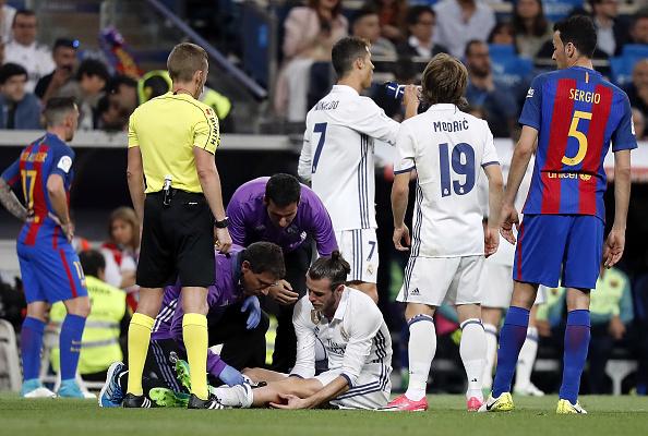 Gareth Bale terlihat mendapatkan perawatan dari tim medis ketika melawan Barcelona. Copyright: Angel Martinez/Real Madrid via Getty Images
