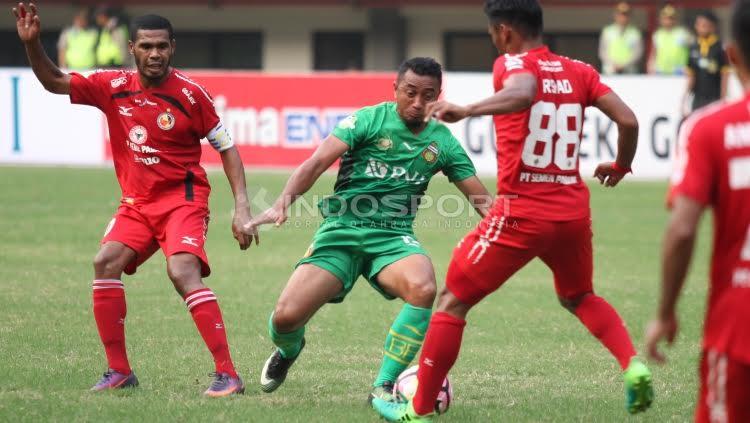 Pemain Bhayangkara FC, Firman Utina (tengah) berebut bola dengan pemain Semen Padang, Irsyad Maulana.