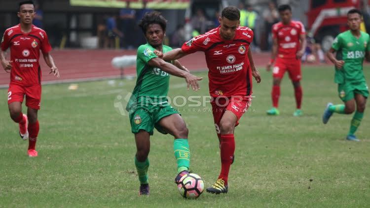 Pemain Bhayangkara FC, Ilham Udin Armaiyn berebut bola dengan bek Semen Padang, Cassio Fransisco De Jesus. Copyright: HERRY IBRAHIM/INDOSPORT