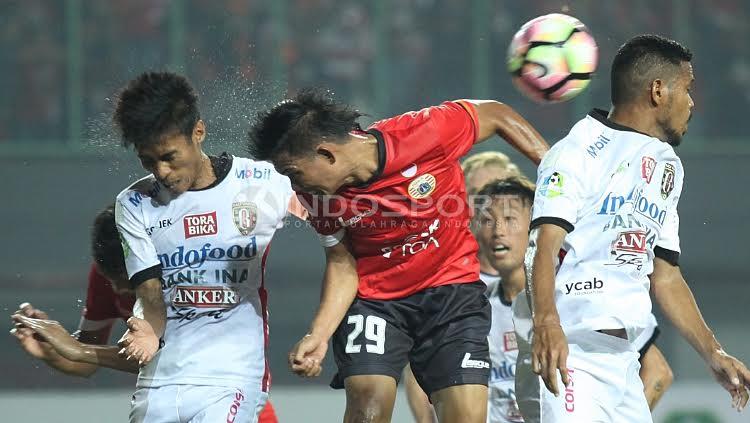 Duel udara antara pemain Persija, Sandi (tengah) dengan Fadil Sausu. Copyright: Herry Ibrahim/Indosport