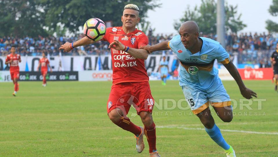 Cristian Gonzales tidak berkutik dengan penjagaan ketat bek Persela, Marcio Rozario sepanjang 90 menit. Copyright: Ian Setiawan/Indosport