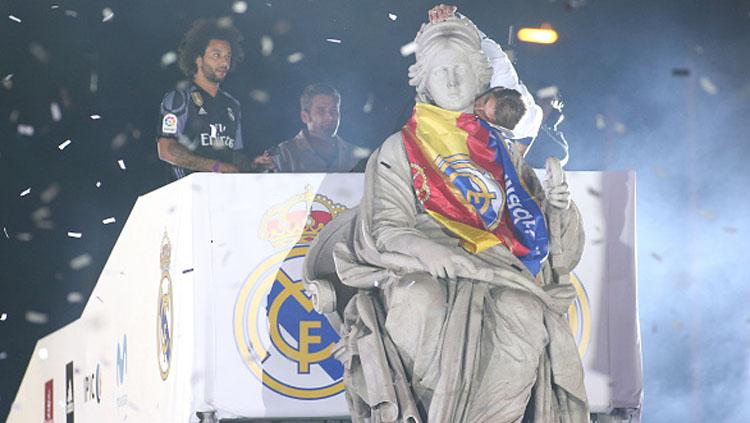 Kapten Real Madrid. Sergio Ramos, mencium patung dewa Cibeles di alun-alun Cibeles setelah memenangkan gelar La liga.