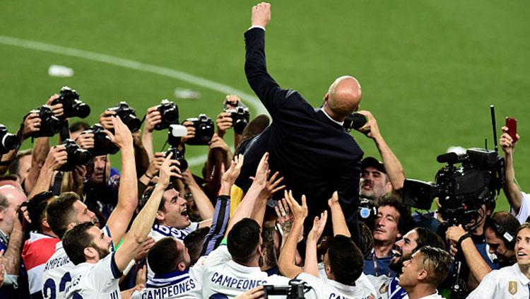 Zinedine Zidane tengah merayakan kemenangan bersama anak asuhnya. Copyright: JOSE JORDAN/AFP/Getty Images