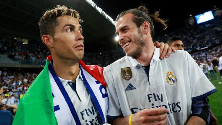 Cristiano Ronaldo dan Gareth Bale berpose dalam perayaan gelar juara Real Madrid. Copyright: Gonzalo Arroyo Moreno/Getty Images