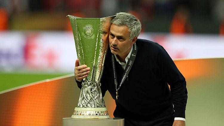 Pelatih Man United, Jose Mourinho, tengah memeluk trofi Liga Europa musim 2016/17.