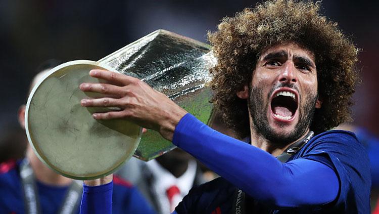 Semangatnya Marouane Fellaini melakukan selebrasi bersama trofi Liga Europa. Copyright: Ian MacNicol/Getty Images