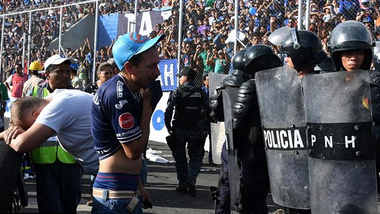 Polisi%20tampak%20berjaga%20ketat%20melawan%20fans%20yang%20nekat%20masuk%20stadion.