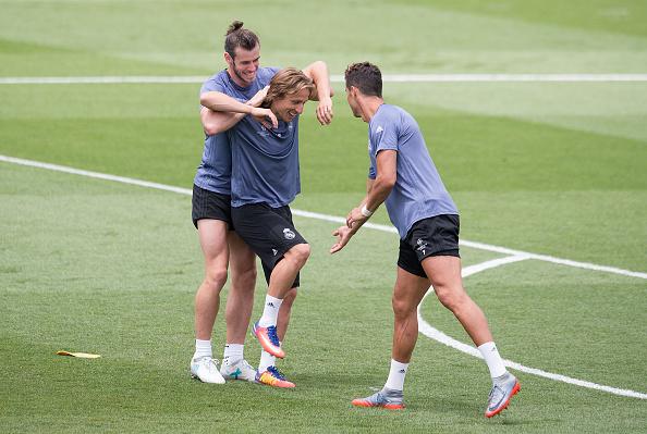 Jelang final, Gareth Bale (kiri) dan Cristiano Ronaldo (kanan)\ sedang mengerjai Luka Modric (tengah) dalam sesi latihan. Copyright: Denis Doyle/GettyImages