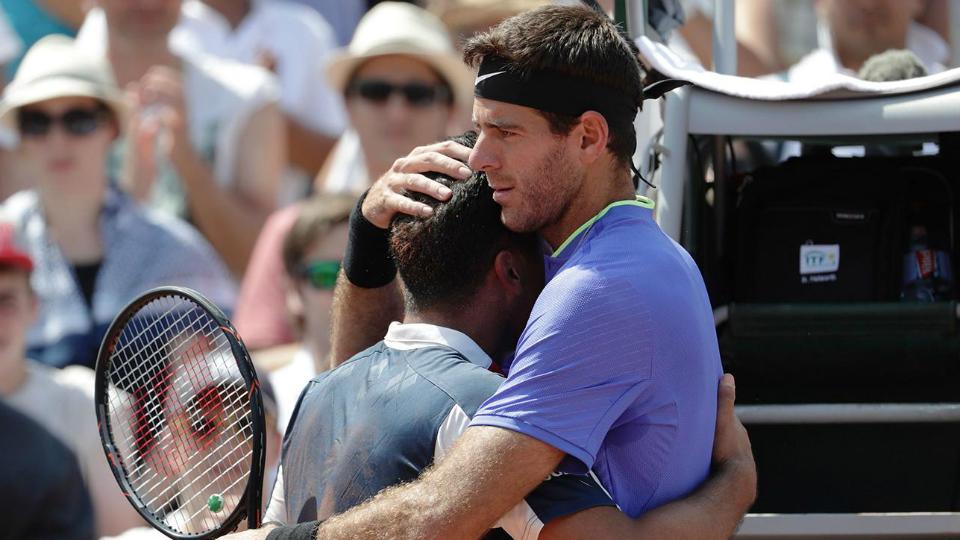 Juan Martin del Potro memeluk Nico Almagro yang cedera. - INDOSPORT