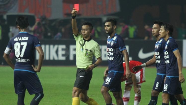 Kapten Arema FC, Johan Alfarizi (kiri) mendapat kartu merah dari wasit.