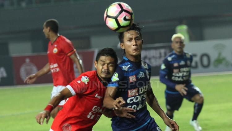 Ikon Persija Jakarta, Bambang Pamungkas (kiri) berebut bola dengan kapten Arema FC, Johan Alfarizi.