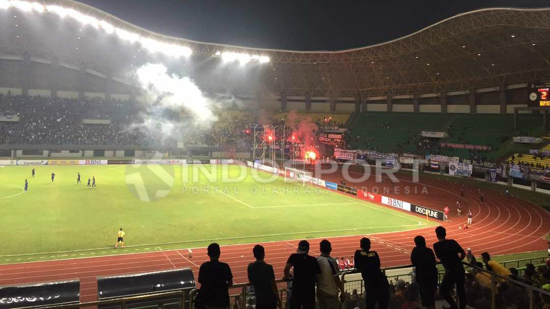 Pendukung Persib Bandung, Bobotoh menyalakan flare sebagai tindakan kurang puas dengan performa tim kesayangannya.