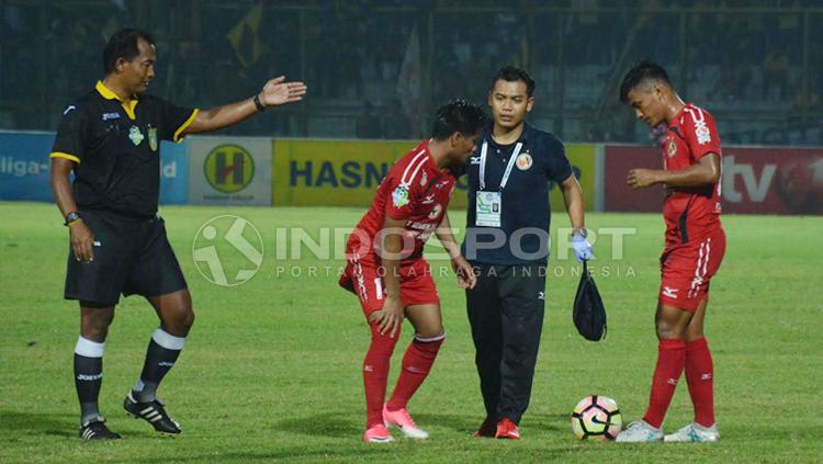 Wasit meminta pemain Semen Padang untuk tinggalkan lapangan guna menerima perawatan. Copyright: Taufik Hidayat/INDOSPORT