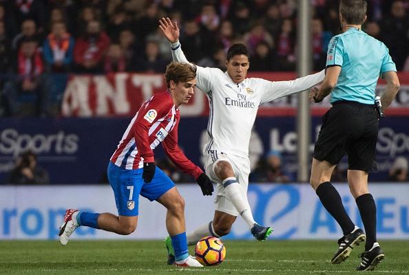 Varane dan Griezmann saling berduel dalam Derby Madrid. Copyright: CURTO DE LA TORRE / Stringer