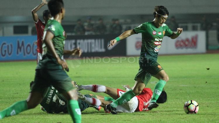 Gelandang PS TNI, Hong Soon-hak melewati hadangan pemain Persija Jakarta.