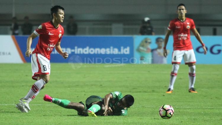 Sutanto Tan melewati hadangan pemain PS TNI.