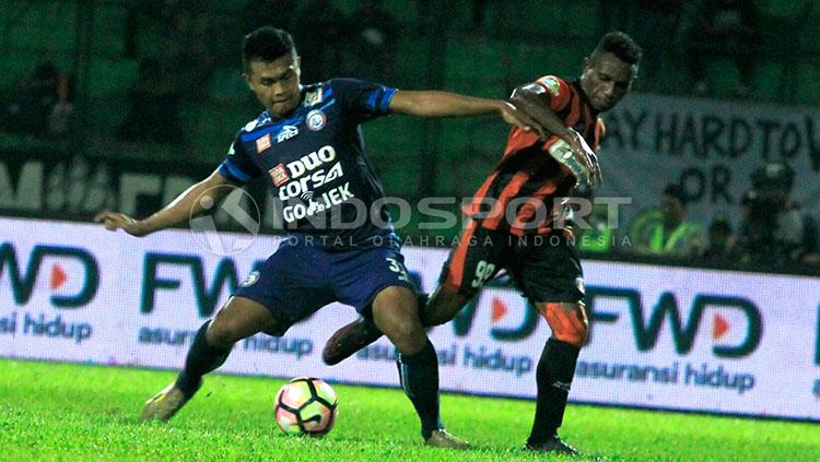 Bek kiri Arema, Junda Irawan saat berebut bola dengan Mariando Uropmabin