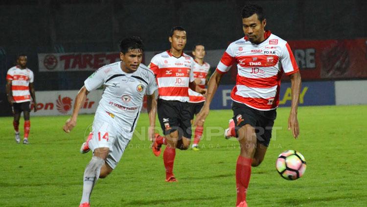Pemain Madura United dan Semen Padang tengah mengejar bola.