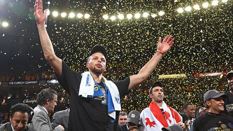 Stephen Curry melambaikan kedua tangannya usai memenangkan pertandingan. - INDOSPORT