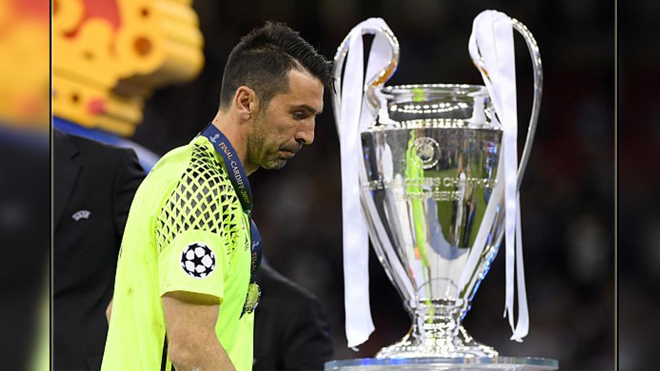 Ekspresi kecewa kiper Juventus, Gianluigi Buffon saat melewati trofi Liga Champions 2016/17. Copyright: INDOSPORT