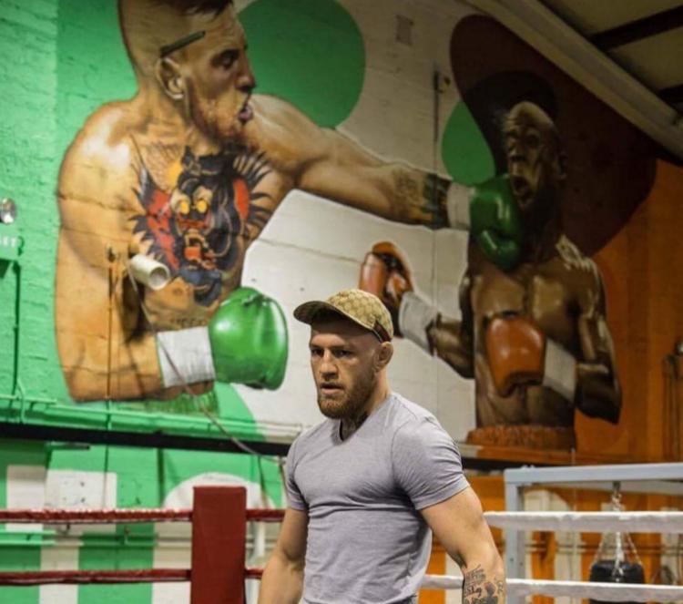 Conor McGregor dengan mural raksasa di gym-nya. Copyright: 