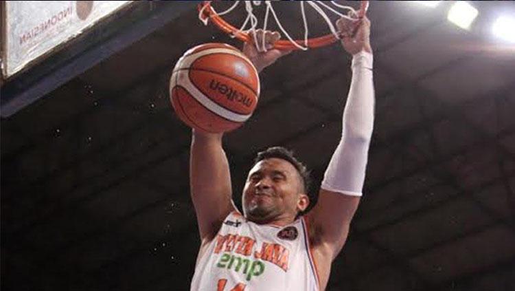 Adhi Pratama saat melakukan slam dunk.