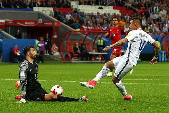 Kiper Portugal, Rui Patricio (kiri) mampu mementahkan peluang dari striker Chile,Eduardo Vargas. Copyright: INDOSPORT