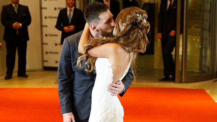 Lionel Messi mencium Antonella Roccuzzo usai pernikahan.