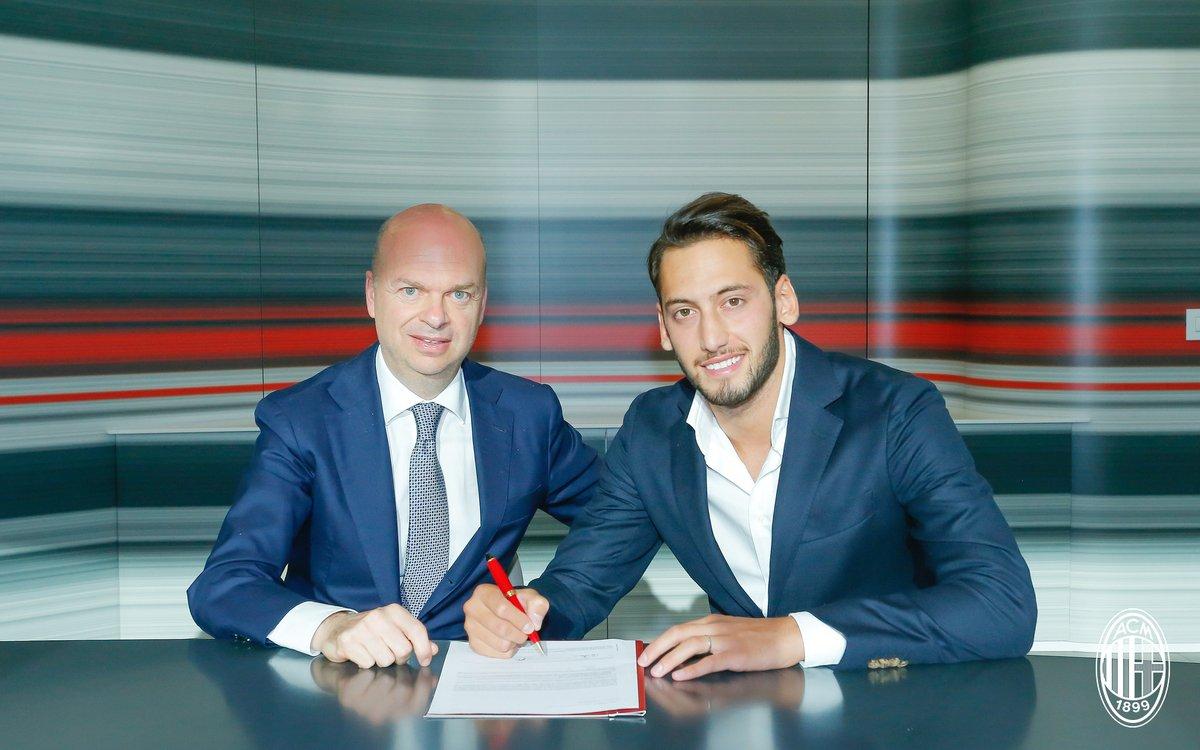 Hakan Calhanoglu saat menandatangani kontrak bersama Milan. Copyright: Twitter AC Milan.