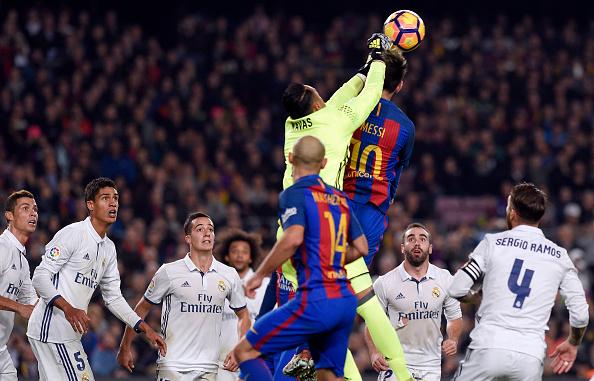 Keylor Navas ketika meninju bola yang hendak disundul Lionel Messi. Copyright: INDOSPORT