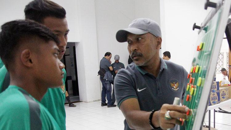 Fakhri Husaini saat menyusun formasin bersama dua pemain Timnas U-16. Copyright: Dewo/PSSI