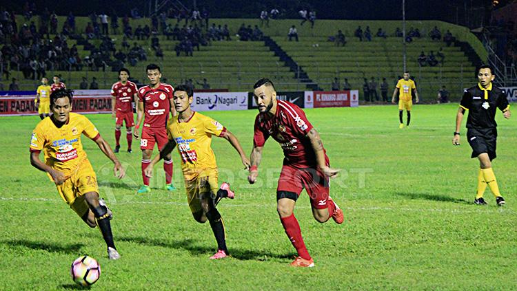 Pemain Semen Padang tengah mengejar bola dan dikawal dua pemain Sriwijaya FC. Copyright: Taufik Hidayat/INDOSPORT