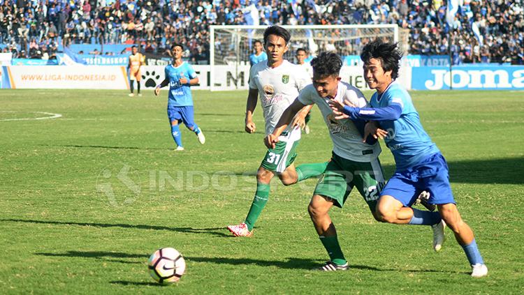 Pemain PSIM Yogyakarta dan Persebaya Surabaya adu bodi untuk mendapatkan bola. Copyright: Prima Pribadi/INDOSPORT