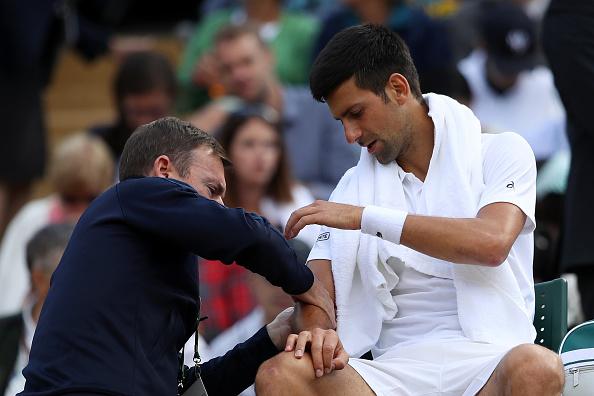 Novak Djokovic saat sedang diobati oleh tim medis. Copyright: INDOSPORT