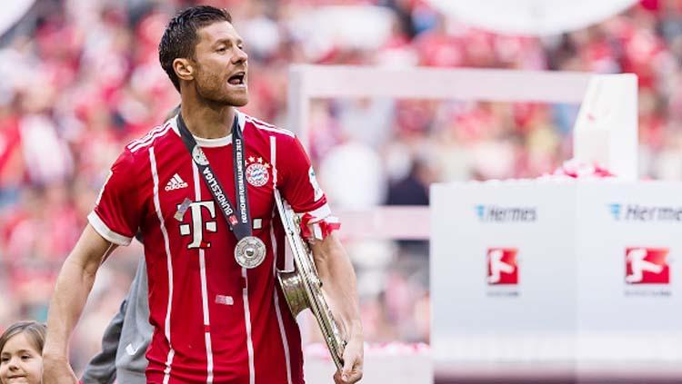 Xabi Alonso melakukan selebrasi bersama tropi Bundesliga. Copyright: INDOSPORT