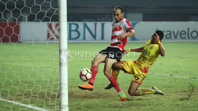 Peter Odemwingie menendang bola ke gawang Madura United. Copyright: Herry Ibrahim/INDOSPORT