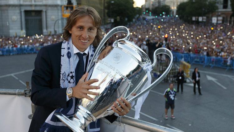 Luka Modric berpose bersama trofi Liga Champions.